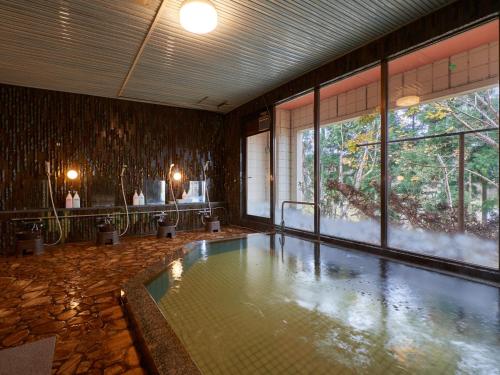 una piscina in una stanza con una grande finestra di Hayamasou a Tokamachi