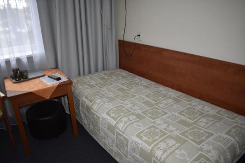 a bedroom with a bed and a desk and a bed sidx sidx sidx at Ośrodek Wypoczynkowy Ania Dźwirzyno in Dźwirzyno