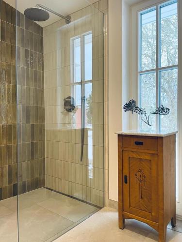 a bathroom with a shower with a wooden table and a glass door at Ferienhaus Slichtemolen in Hessenburg