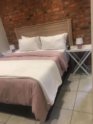 a bedroom with a bed and a table with a night stand at Euphoria in Nelspruit