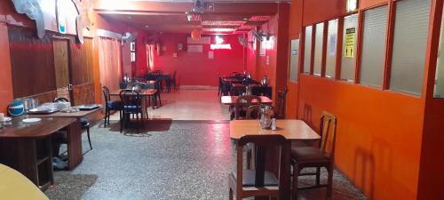comedor con mesas, sillas y paredes rojas en Hotel Abhishekh, en Port Blair