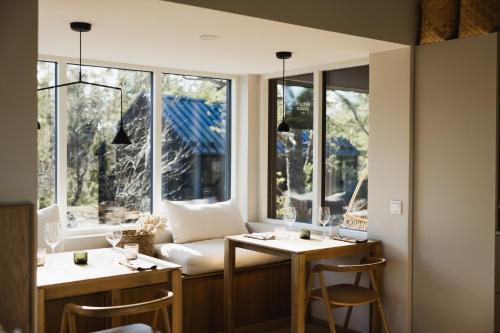 Cette chambre dispose de fenêtres, d'une table et de chaises. dans l'établissement Hilltop Forest, à Inkoo