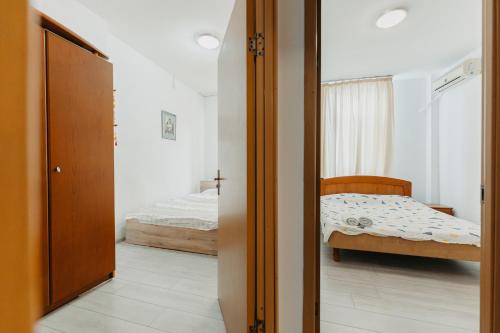een slaapkamer met een bed en een deur naar een slaapkamer bij Apartament Piata Amzei 1 (17 B) in Boekarest