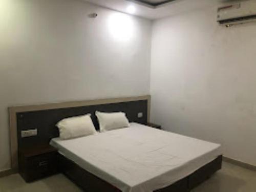una camera da letto con un grande letto con due cuscini di Hotel Paradise Shivpur , Varanasi a Varanasi