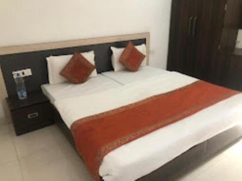 una camera da letto con un grande letto con cuscini rossi e bianchi di Hotel Paradise Shivpur , Varanasi a Varanasi