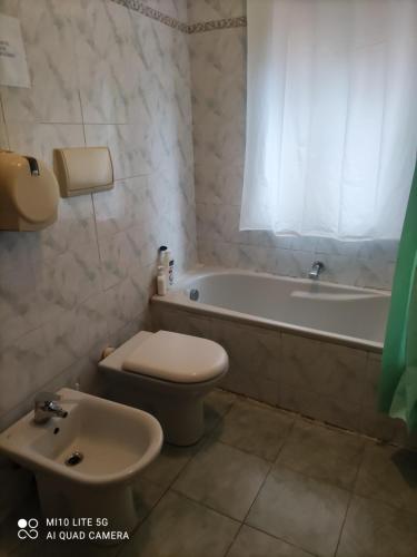 La salle de bains est pourvue d'une baignoire, de toilettes et d'un lavabo. dans l'établissement HOSTAL D'ANNUNZIO HOUSe, à Cesano Boscone