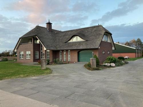 a large brick house with a large garage at Vakantiehuis Stobben in Bourtange