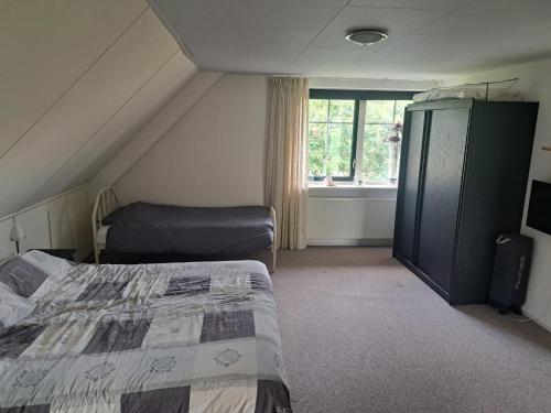 um pequeno quarto com uma cama e uma janela em Vakantiehuis Stobben em Bourtange