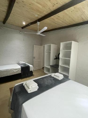 a bedroom with two beds and a ceiling at Kruger Wild Dog Inn in Marloth Park