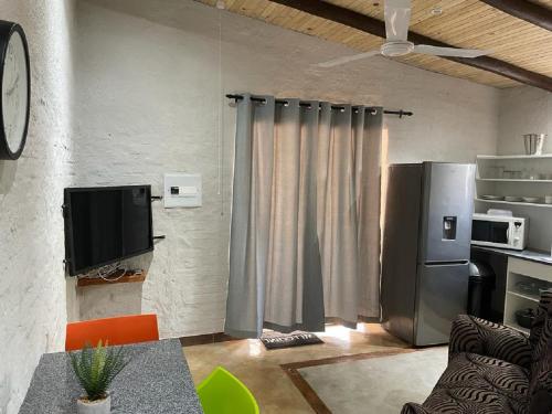 a living room with a refrigerator and a television at Kruger Wild Dog Inn in Marloth Park