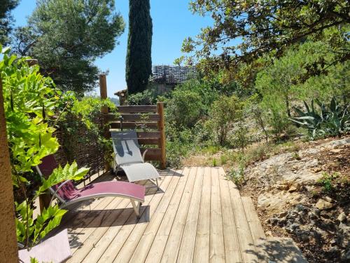 two benches sitting on a wooden walkway at Les Garrigues de la Vallée des Baux in Paradou
