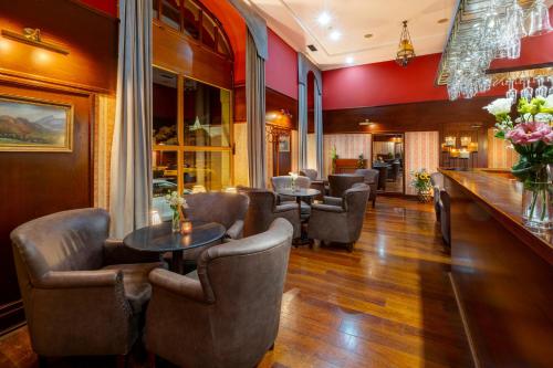 a restaurant with chairs and tables and a bar at Hotel Golden Eagle in Levice