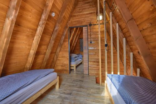 a room with two beds in a wooden cabin at Domki Na Grapie in Międzybrodzie Bialskie