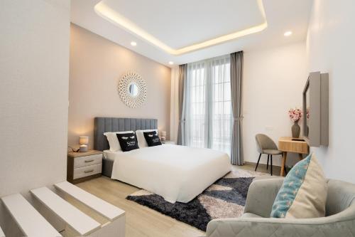 sypialnia z białym łóżkiem i kanapą w obiekcie WONDERLAND HỒ TRÀM w mieście Ba Ria