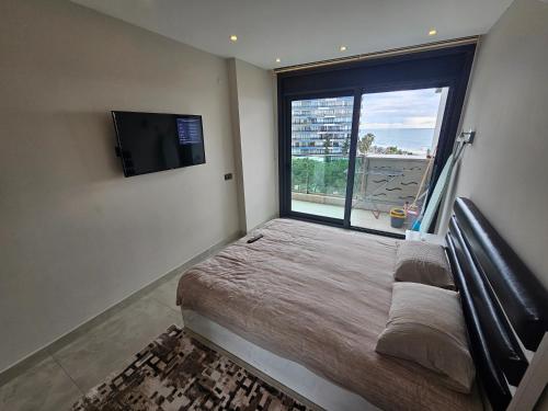阿拉尼亞的住宿－Konak Tower Seaside mahmutlar，一间卧室设有一张床和一个大窗户