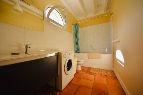 a bathroom with a washing machine and a toilet at Le Petit Clos De Gorre in Martillac