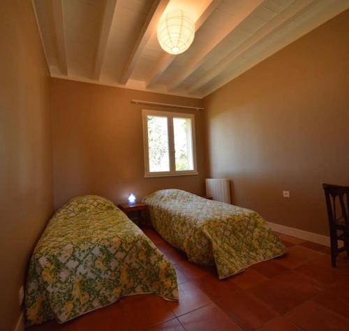 2 camas en un dormitorio con ventana en Le Petit Clos De Gorre, en Martillac