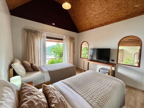 een hotelkamer met 2 bedden en een televisie bij Baan Talay Resort & Yoga in Ko Tao