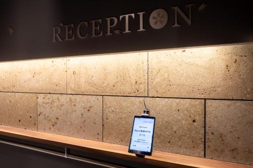 Un teléfono celular sobre un mostrador en una tienda en 松山大街道HOTELさくら- unmanned hotel -, en Matsuyama