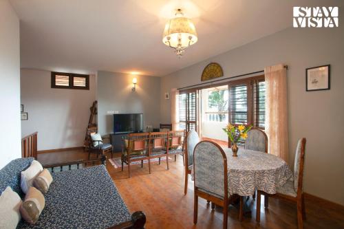 a living room with a table and a dining room at 3BR Mercara Hill Villa with Outdoor Jacuzzi and Complimentary breakfast - Coorg in Madikeri