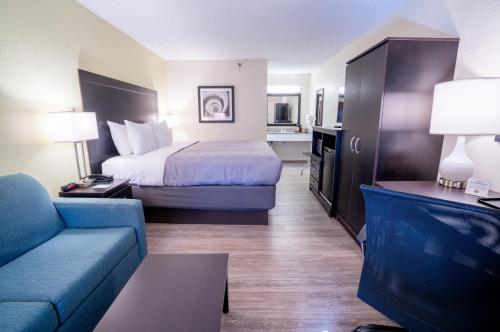 a hotel room with a bed and a couch at Quality Inn Palm Beach International Airport in West Palm Beach