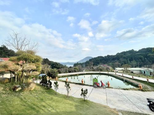 a bridge over a river with a person on a motorcycle at Scent Village Hotel in Da Lat