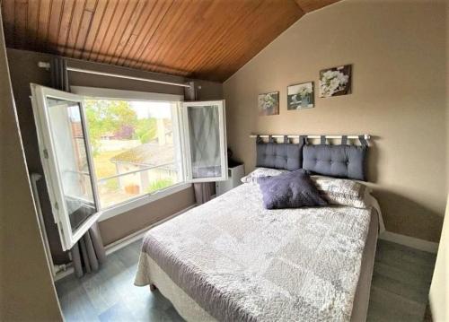 une chambre avec un lit et une grande fenêtre dans l'établissement La petite auberge, à Châtelraould-Saint-Louvent