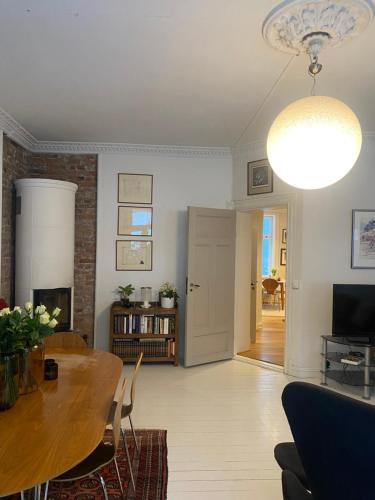 a living room with a dining room table and a lamp at Lovely two bedroom flat in central Oslo in Oslo