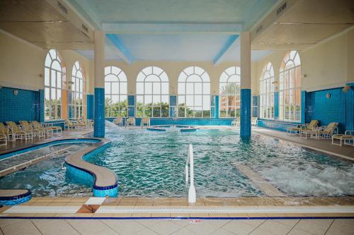 a swimming pool in a building with a water slide at Hotel Nour Palace Resort & Thalasso Mahdia in Mahdia
