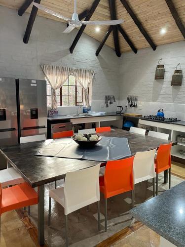 a kitchen with a large table with orange chairs at Kruger Wild Dog Inn in Marloth Park