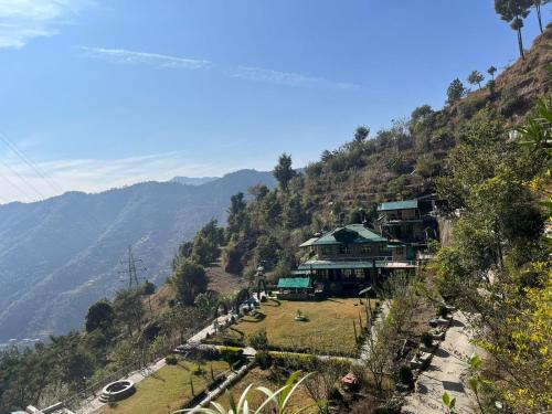 un edificio al lado de una montaña en Green Lodge Farmstay by Highland Monk, en Shimla