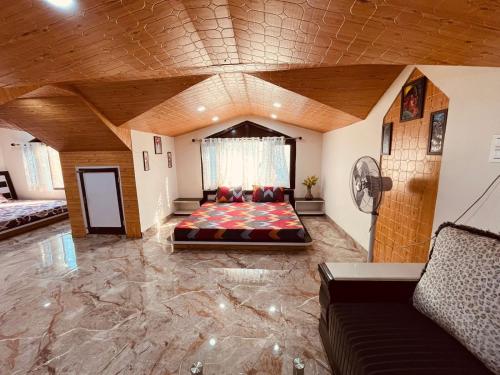 Habitación grande con cama y sofá en Green Lodge Farmstay by Highland Monk, en Shimla