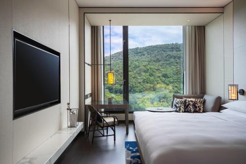 a hotel room with a bed and a large window at Renaissance Taipei Shihlin Hotel in Taipei