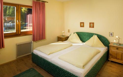 a bedroom with a green bed with two pillows at Appartementhaus Turracher Höhe in Turracher Hohe