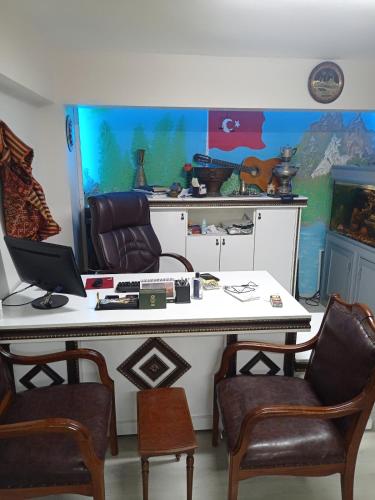 a room with a desk with two chairs and a laptop at Sahin Home Office in Istanbul