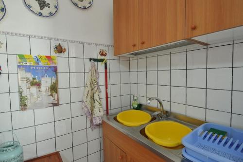 une cuisine avec deux lavabos jaunes sur un comptoir dans l'établissement Appartamento Zii Mpeu by Salentoaffitti, à Racale