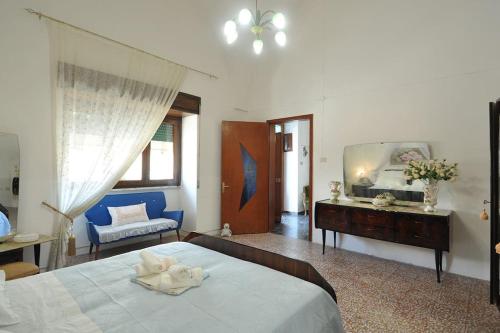 - une chambre avec un grand lit et un canapé bleu dans l'établissement Appartamento Zii Mpeu by Salentoaffitti, à Racale