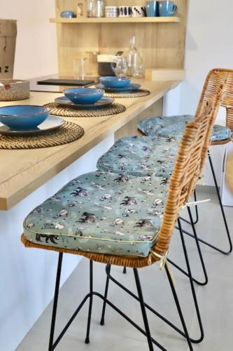 - une table avec deux chaises en osier et des plats bleus dans l'établissement Paradis Bleu - Vue Lac avec Terrasse & Garage, à Annecy