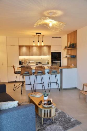 un salon avec un canapé et une cuisine dans l'établissement Paradis Bleu - Vue Lac avec Terrasse & Garage, à Annecy