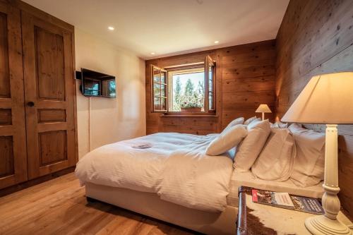 a bedroom with a bed and a window at Chalet with a beautiful view on the heights of in Verbier