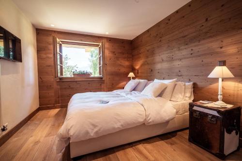 a bedroom with a large bed with a wooden wall at Chalet with a beautiful view on the heights of in Verbier