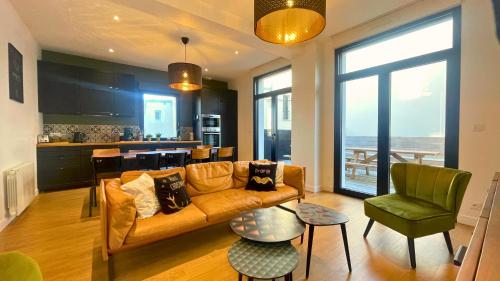 un salon avec un canapé et une cuisine dans l'établissement AU 43 BIS, à Granville