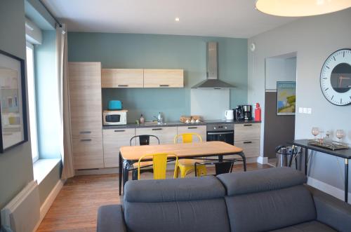 une cuisine et une salle à manger avec une table et des chaises jaunes dans l'établissement Digue, à Wimereux