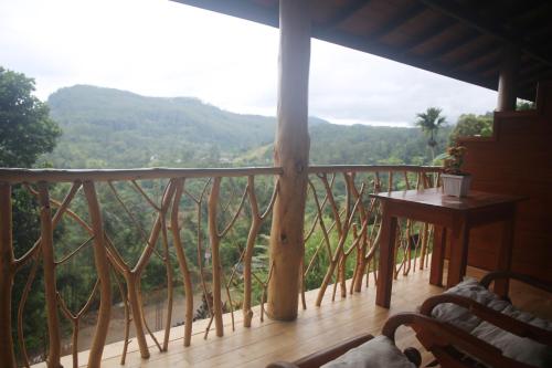 uma varanda com uma mesa e vista para as montanhas em The Dream Inn em Ella