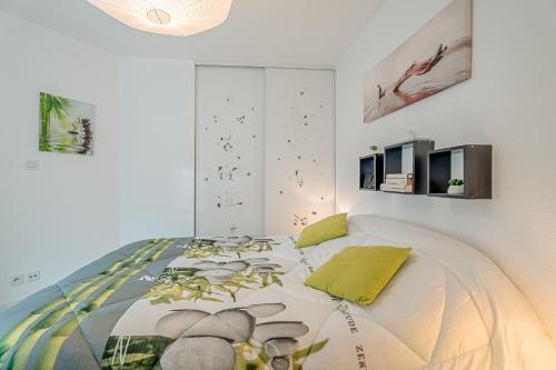 ein Schlafzimmer mit einem Bett mit einer Bettdecke in der Unterkunft Appartement Les Bains - Erquy in Erquy