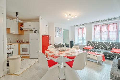 una cucina e un soggiorno con tavolo e sedie di Appartement Les Bains - Erquy a Erquy