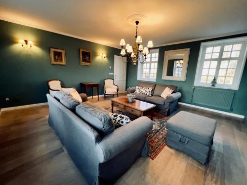 a living room with two couches and a table at Château le Withof in Bourbourg