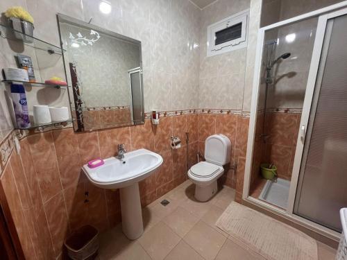 a bathroom with a sink and a toilet and a shower at Beautiful 2-Bed Apartment in Rabat Hay Riad in Kouas