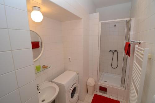 a white bathroom with a toilet and a sink at Apartments Karlin in Prague
