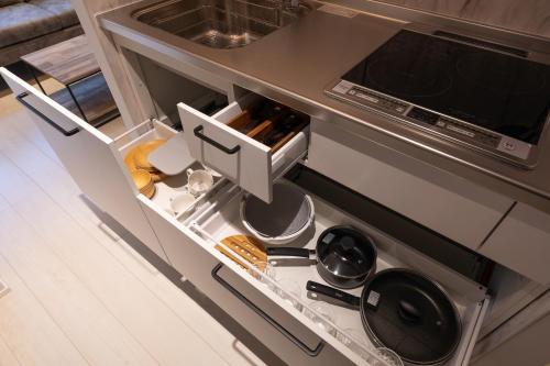 a kitchen with an open cabinet with a stove at 松山大街道HOTELさくら- unmanned hotel - in Matsuyama